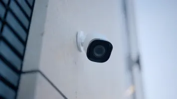 An einer Außenwand montierte Outdoor Überwachungskamera zur Beobachtung von Eingangsbereich und Fassade.