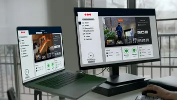 Laptop und Monitor zeigen ein Sicherheitsdashboard mit Livebildern, Zutrittsstatus und Steuerung über eine Videoüberwachungs-App.