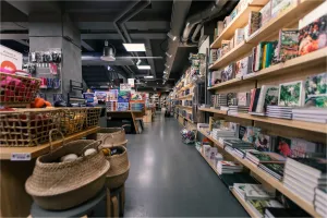 Blick in einen gut sortierten Verkaufsraum mit Regalen voller Bücher, Körben mit Waren und Zubehörartikeln – ideale Umgebung für diskrete Sicherheitslösungen.