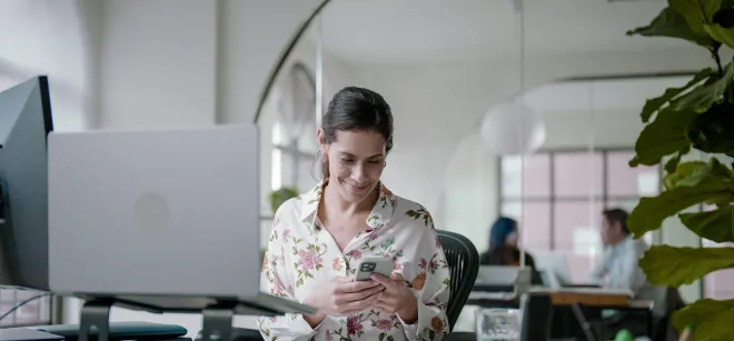 Headerbild Bundles Übersicht Zufriedene Geschäftsfrau nutzt Securitas Connect App im Büro